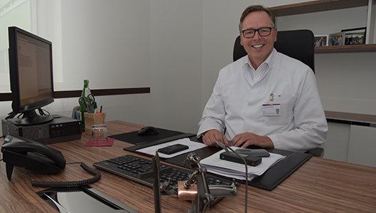 Chefarzt Dr. Ludwig am Schreibtisch