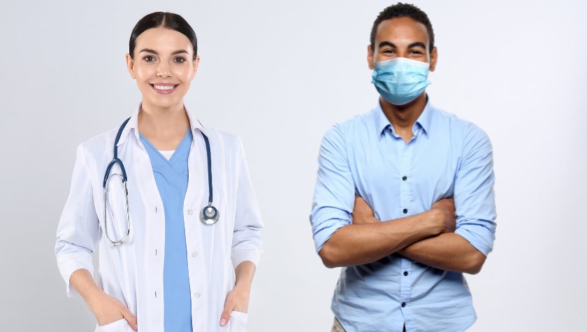 Eine Ärztin ohne Maske und ein Mann mit Maske stehen nebeneinander