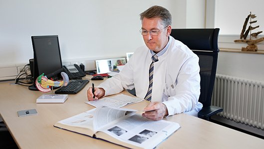 Dr. Kai Wiemer am Schreibtisch
