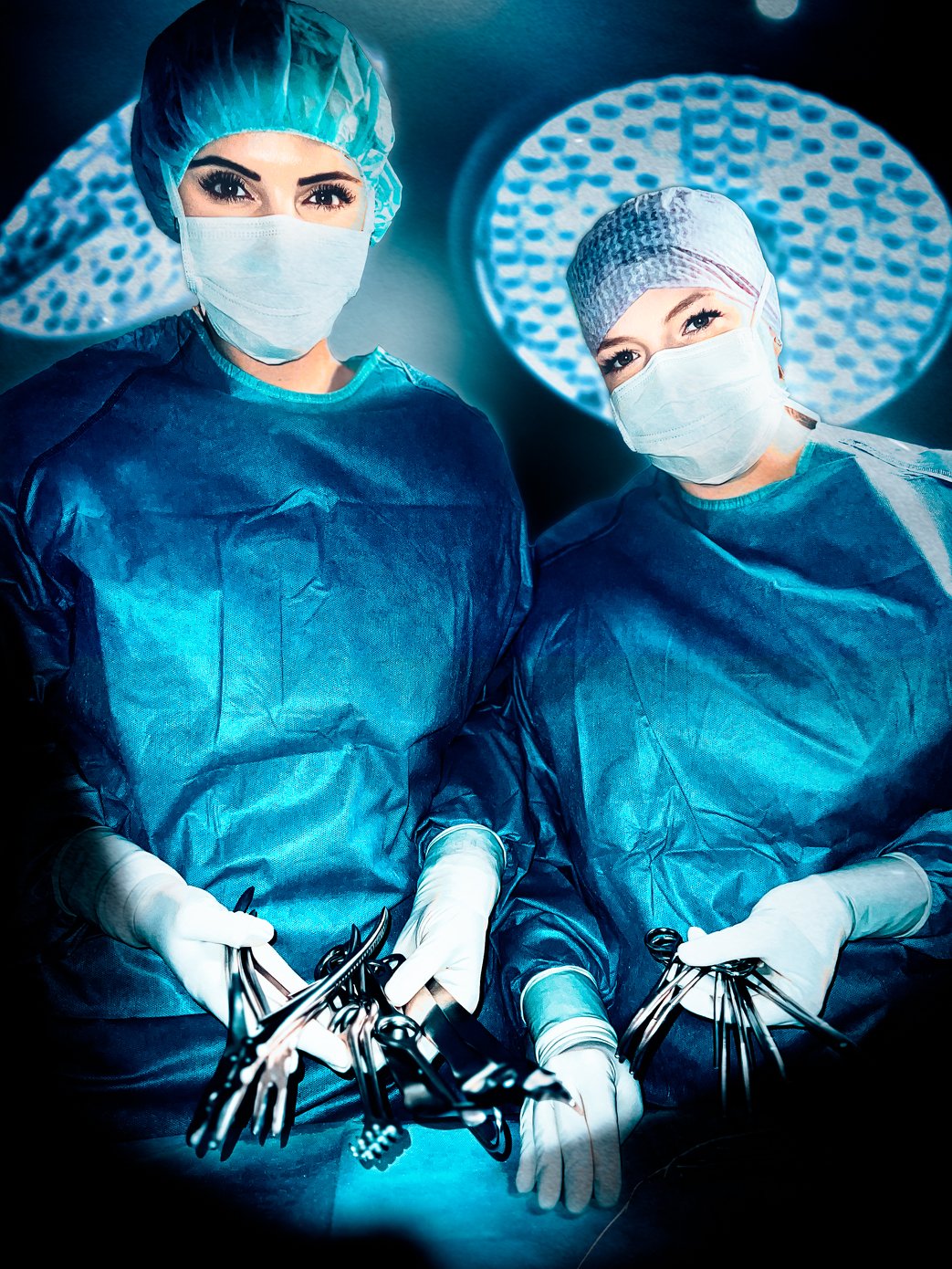 Zwei weibliche OP-Pflegekräfte stehen am OP-Tisch mit Operationswerkzeugen