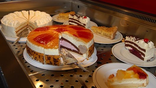 Cafeteria - Symbolbild: mehrere Tortenplatten mit frischem und leckeren Kuchen