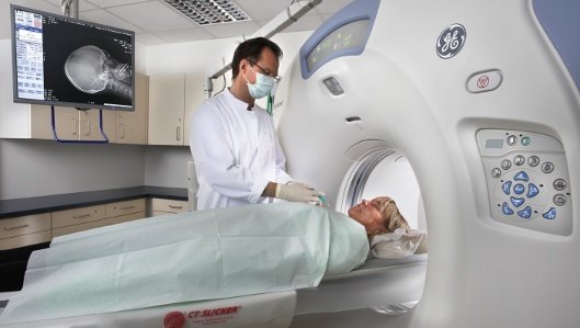 Dr. Markus Braun mit einer Patientin am MRT