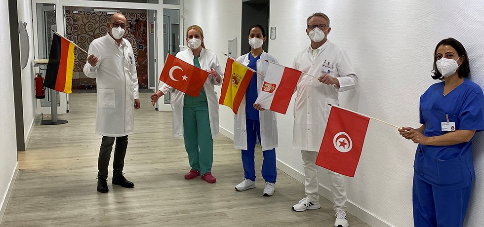 Das ärztliche Team zeigt die Flaggen seiner Herkunftsländer
